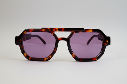 A pair of aviator style sunglasses with a tartarooga frame and purple lenses.